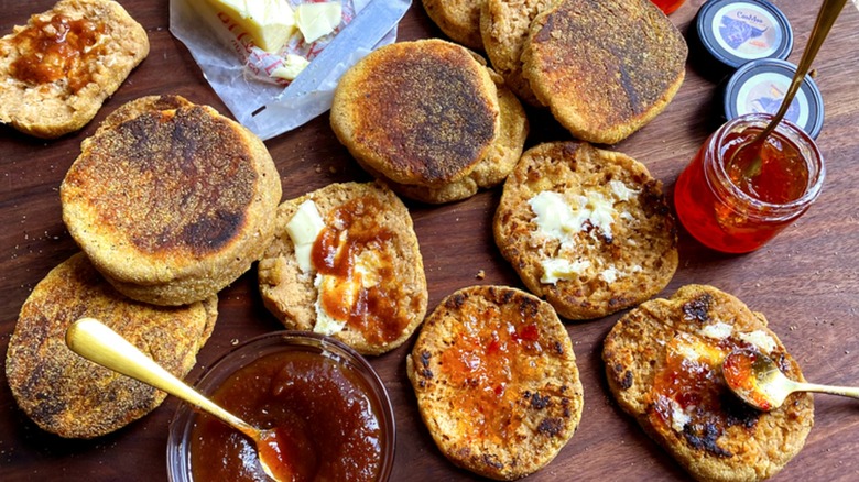 An assortment of homemade English muffins with butter and jam