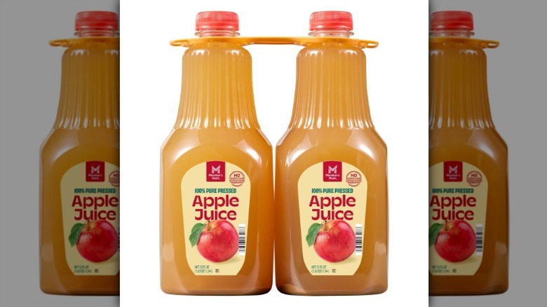 Two bottles of Member's Mark 100% Pure Pressed Apple Juice on a white background.