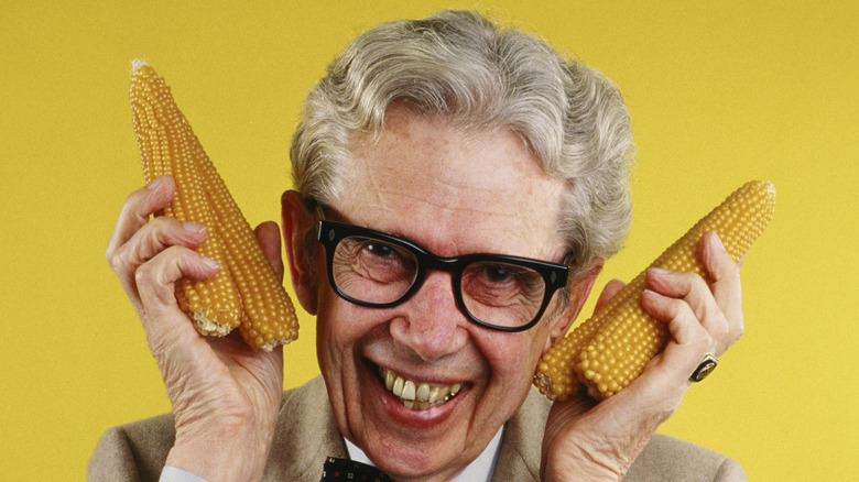 Orville Redenbacher holding several ears of corn
