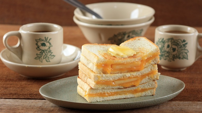 Kaya Toast piled up on a plate with cups of coffee