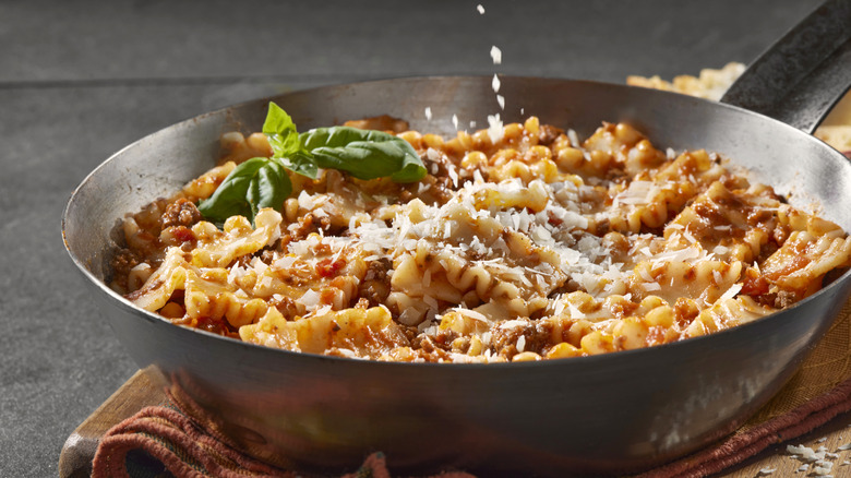 Skillet lasagna garnished with a sprig of basil and freshly grated cheese