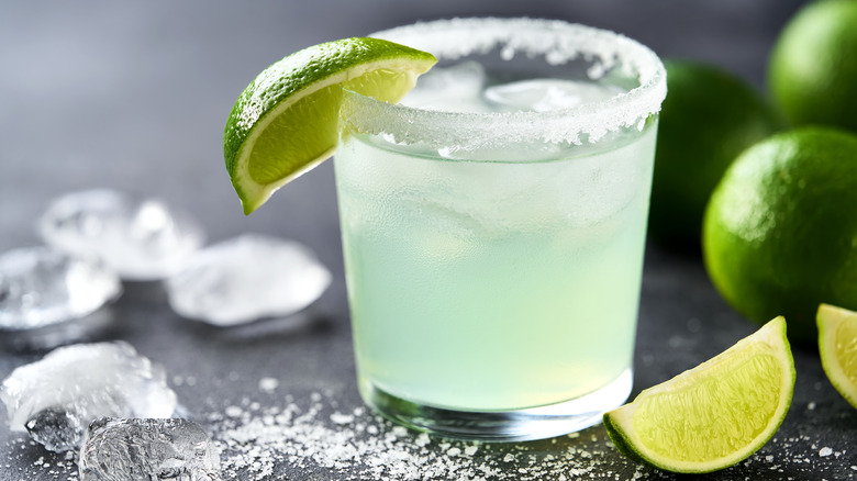 Margarita in a rocks glass with a salted rim and wedge of lime.