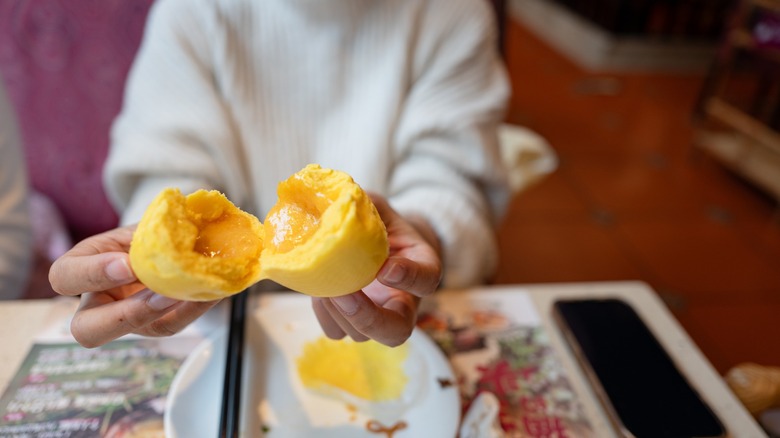 Close up woman holding a broken open Liu Sha Bao