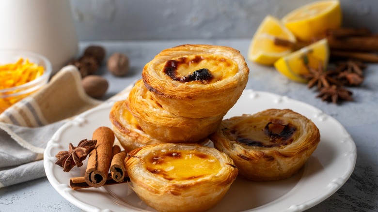 Several Pastel de Nata desserts, stacked on a plate