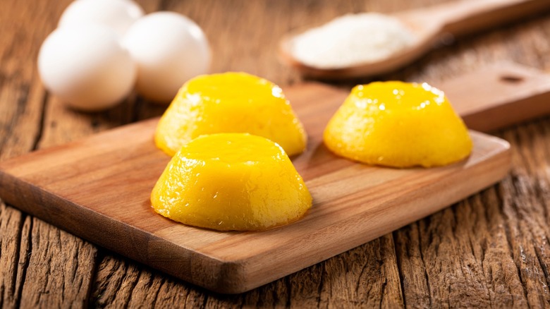 Three quindim on a wooden board