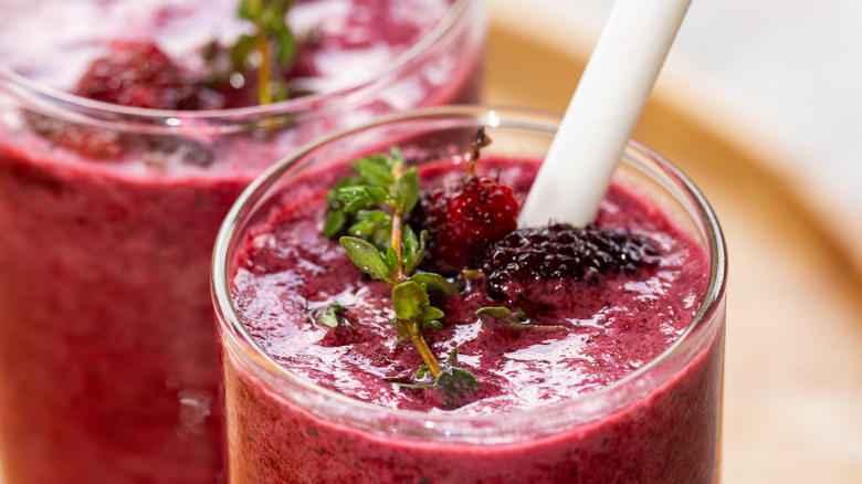 Glass filled with mulberry smoothie and garnished with mulberries
