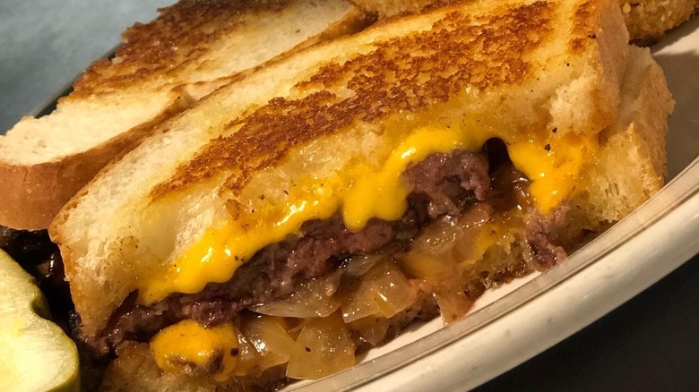 Cheeseburger with sautéed onions on white bread
