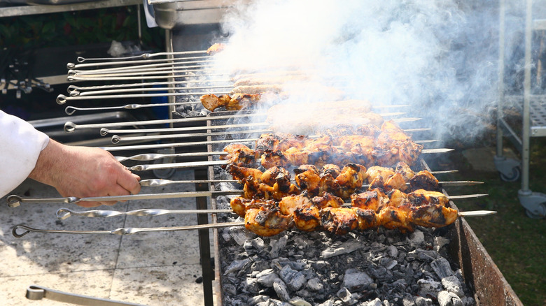Chef turning grilling meats