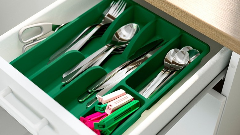 green Smäcker flatware tray holding forks, spoons, butter knives, bag clips, and kitchen shears
