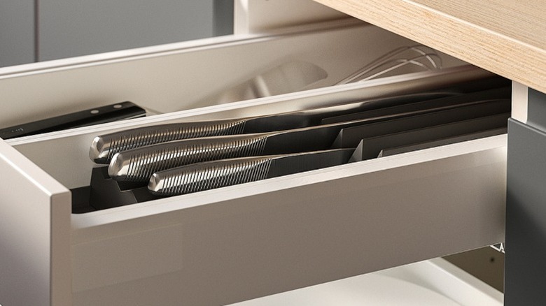 Uppdatera knife rack holding three knives sitting in a white kitchen drawer