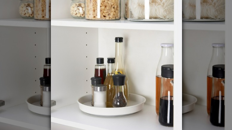 Variera lazy susan in a pantry holding assorted seasonings and condiments in glass jars and bottles