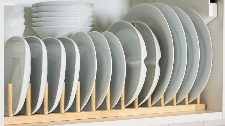 Ostbit bamboo plate holder in a cabinet holding white plates