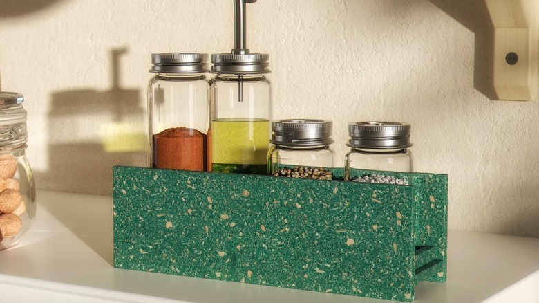 Hundhaj spice rack holding four glass bottles and jars of condiments and spices sitting in a pantry