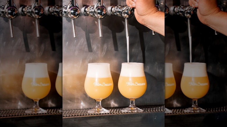 Two glasses of beer under taps