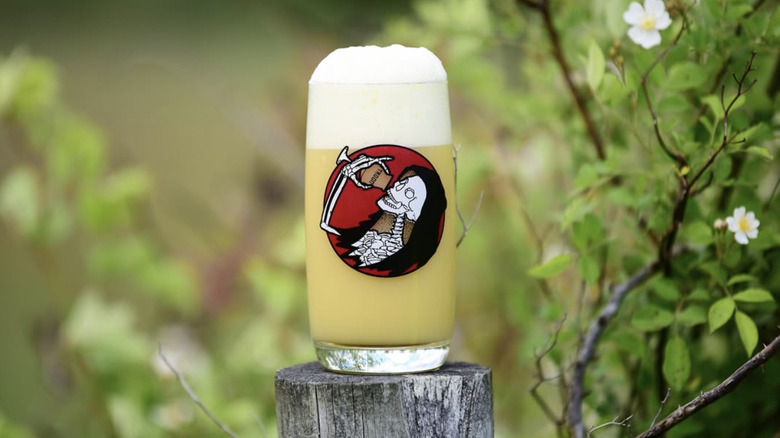 Beer with a thick foam in a glass with a skeleton graphic
