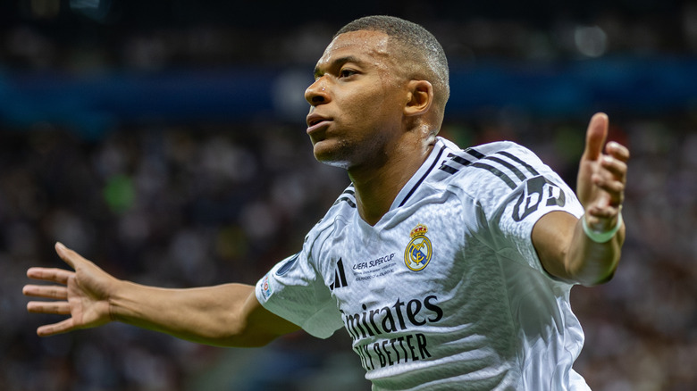 Kylian Mbappé spreading his arms while playing soccer