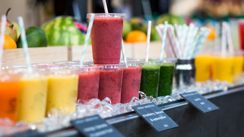 Row of colorful drinks and smoothies in clear go cups