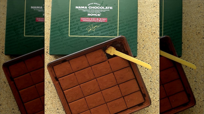 An open box of Royce Nama Chocolate Champagne Pierre Mignon candies with a serving spoon