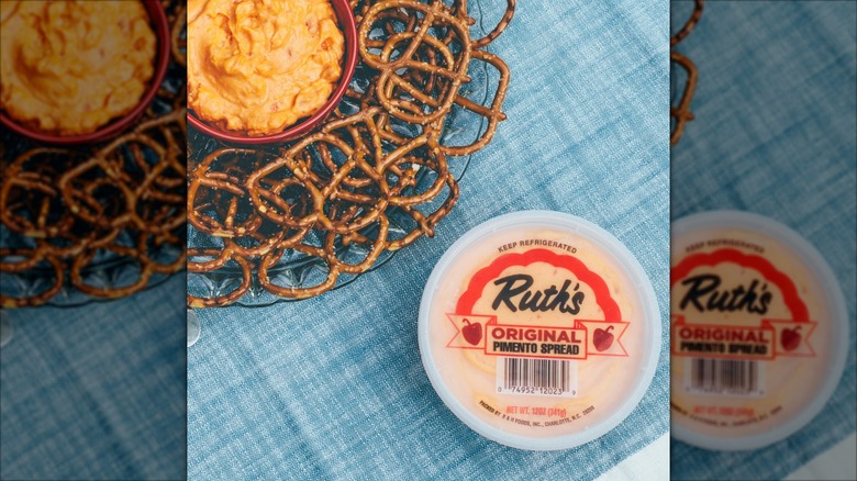 Ruth's Original Pimento Cheese Spread container beside a bowl of the spread and pretzels
