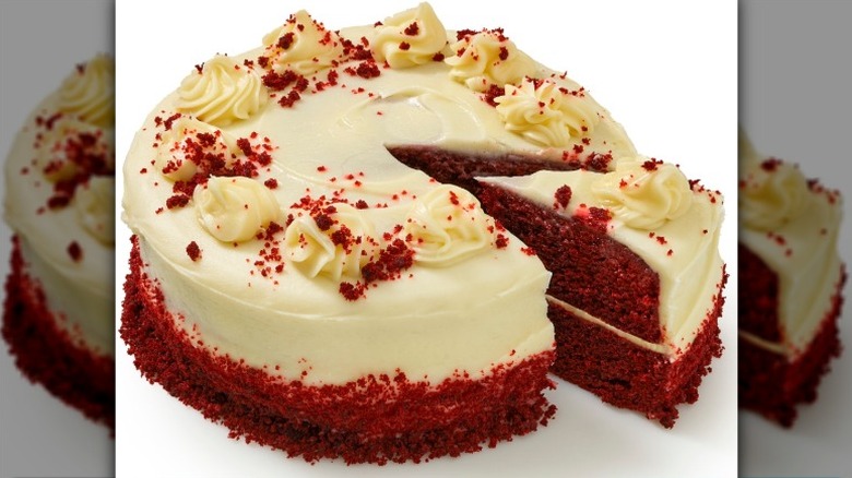 Bakery Fresh Cream Cheese Iced Red Velvet Cake from Kroger with one slice separated on a white background.