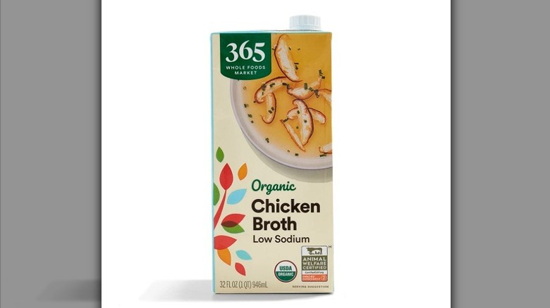 A carton of 365 Organic Low Sodium Chicken Broth on a white background