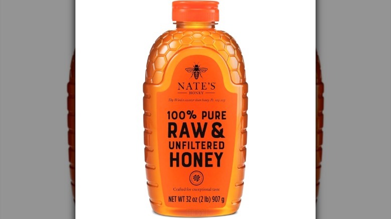 A bottle of Nate's 100% Pure, Raw, & Unfiltered Honey on white background