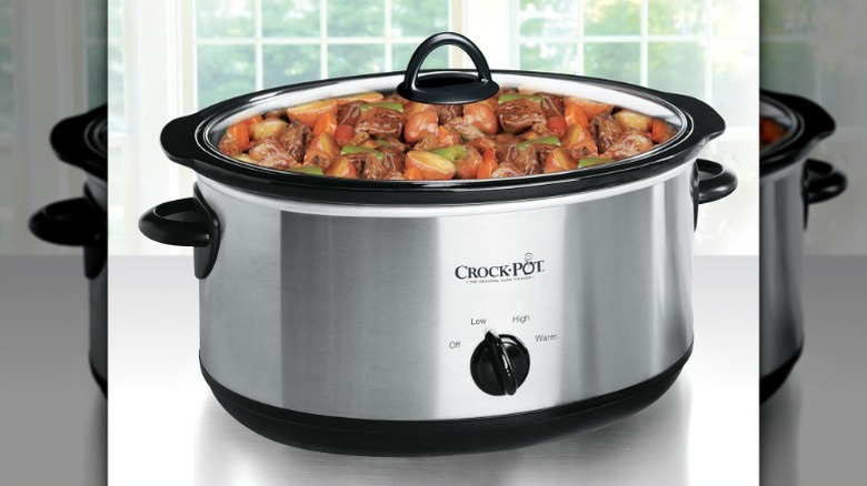 oval Crock-Pot-branded crockpot in a stainless-steel finish filled with beef stew