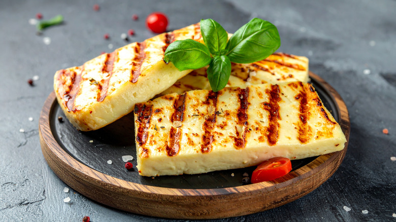 grilled Halloumi slices garnished with fresh mint on wooden serving board