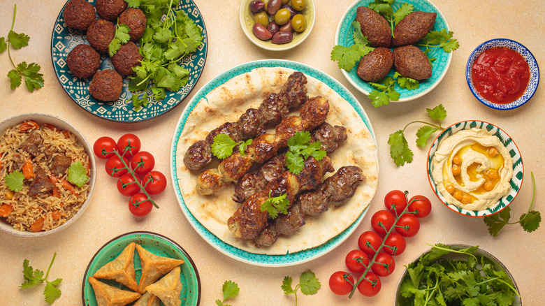 Mezze, a collection of many middle eastern dishes on decorative plates, including hummus, falafel, and shawarma
