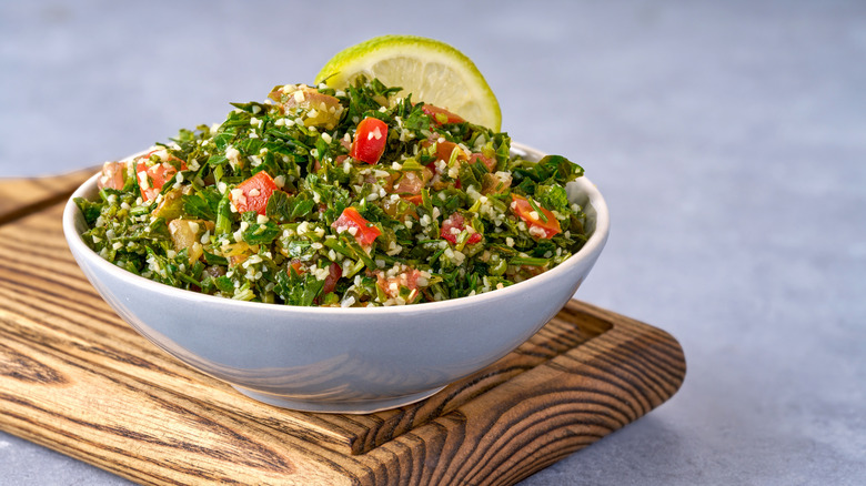 Tabbouleh salad in a bowl with lemon wedge