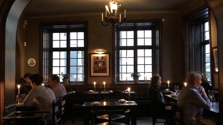 Den Gyldene Freden darkened dining room with diners eating by candlelight