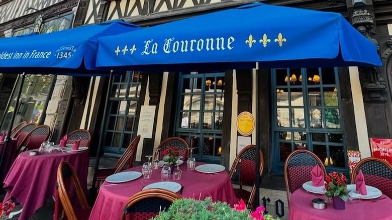 La Couronne outdoor seating area with blue awnings