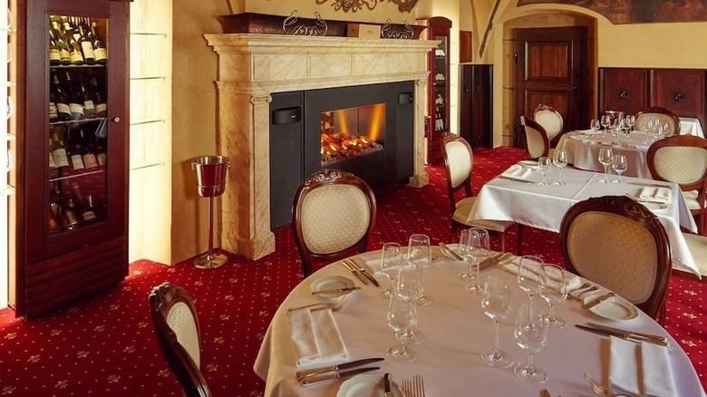 U Maliru dining room with fireplace and wine