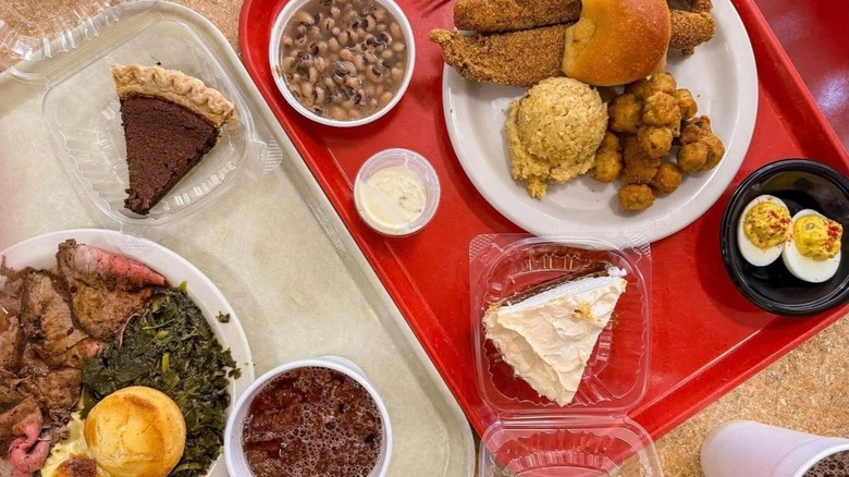 Two cafeteria trays with lunch, dessert, and drinks