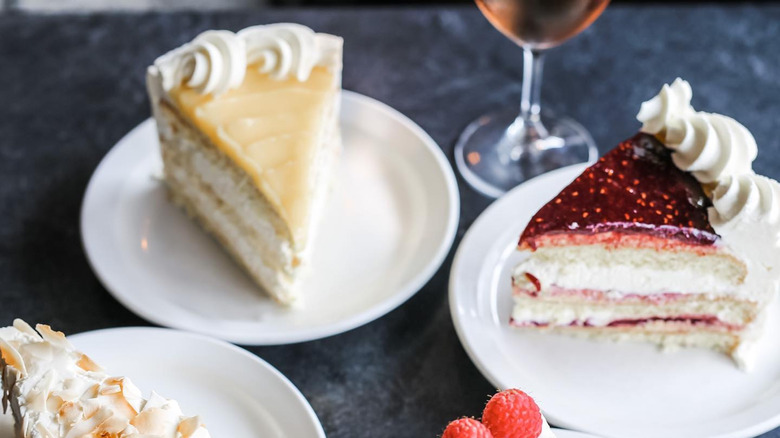 Cakes on plates with wine in backdrop