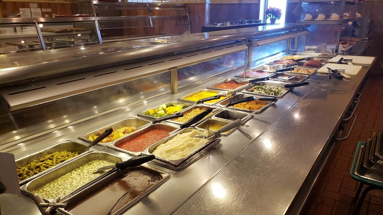 Cafeteria food lineup with hot trays in old-school restaurant