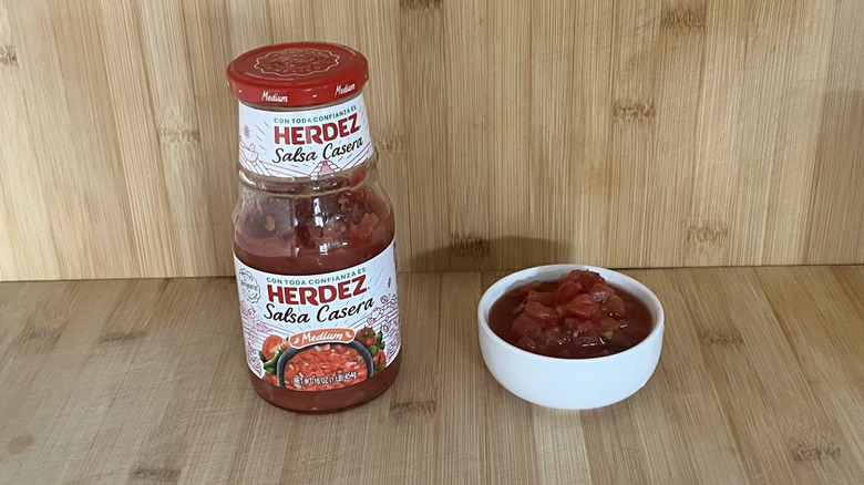 A bottle of Herdez salsa alongside a little bowl of it