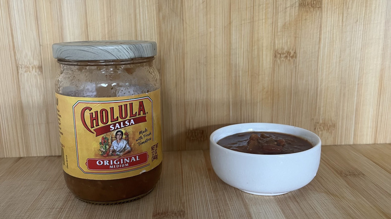 A jar and small bowl of Cholula salsa