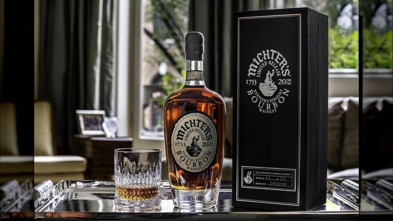 Bottle and glass of Michter's 20 with presentation box on silver tray
