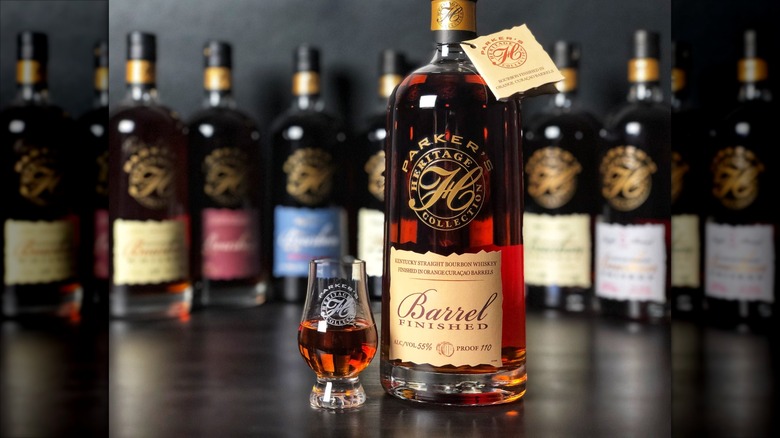 Bottle of barrel-finished bourbon from the Parker's Heritage Collection bottles blurred in background