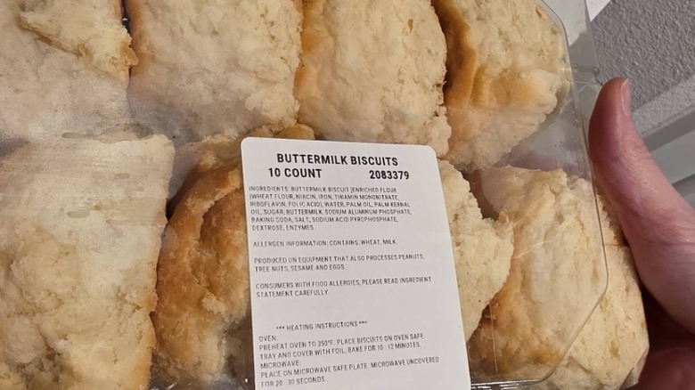 A closeup of someone holding a package of Costco Buttermilk Biscuits in a clear plastic clamshell