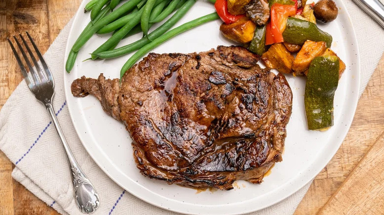 Marinated steak with a side of green beans and mixed vegetables