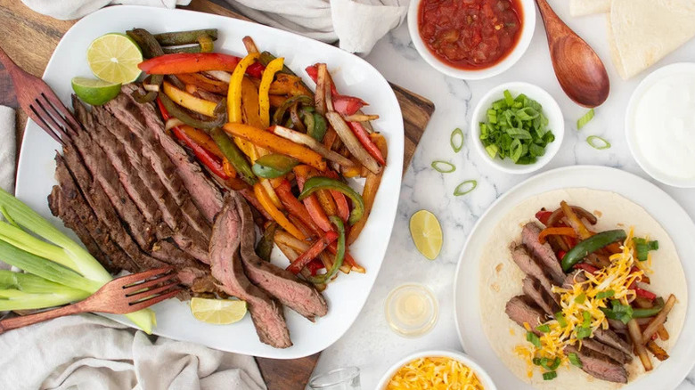 Plates of steak fajitas with sides and garnishes