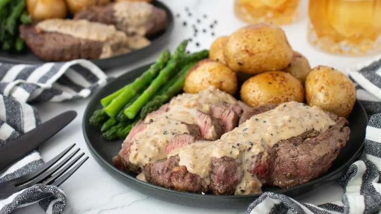 Steak in a whiskey cream sauce, served with sides