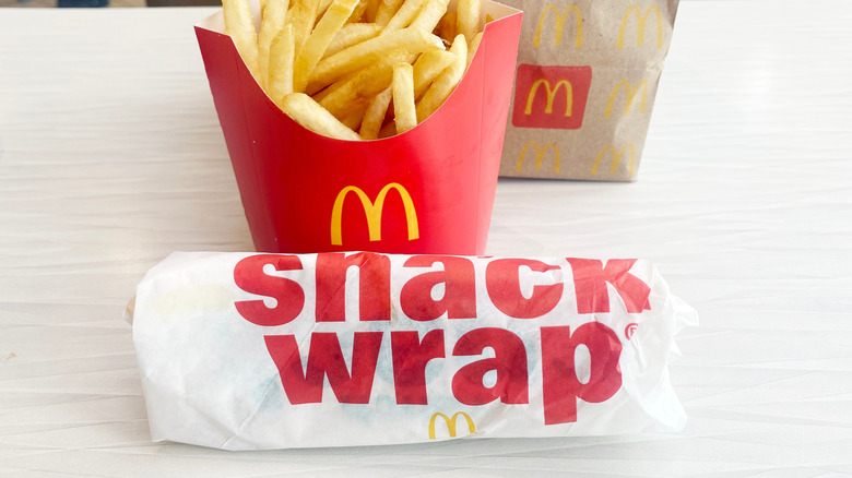 A wrapped snack wrap positioned in front of McDonald's fries.