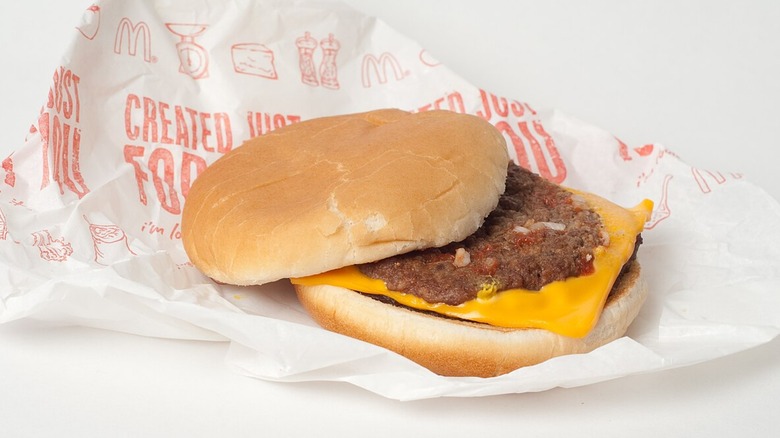 A McDonald's McDouble resting half-open on wax paper.