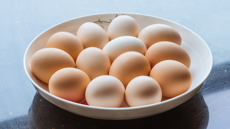 whole eggs on white plate on dark countertop