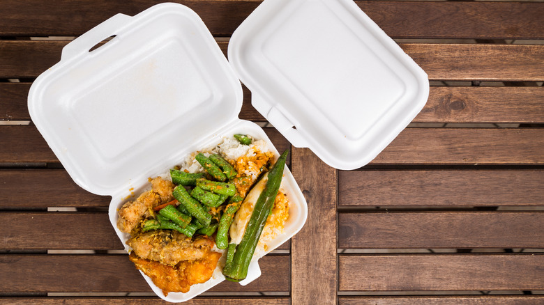 two styrofoam takeout containers one open with food