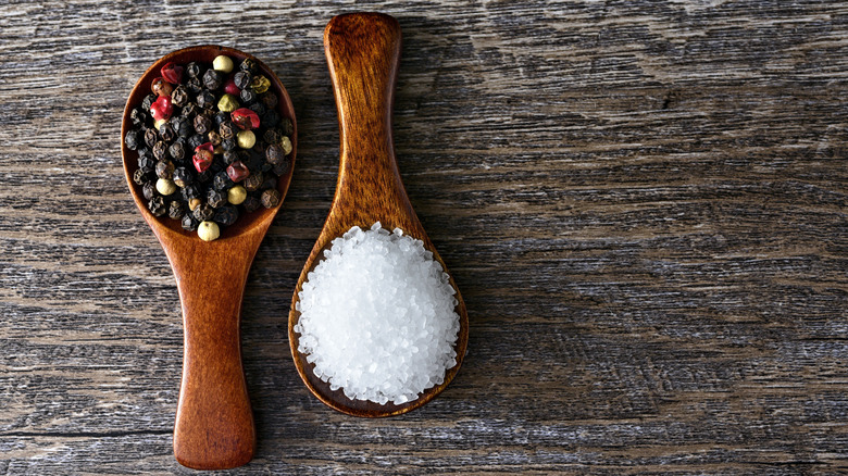 Spoons of peppercorns and flaky salt