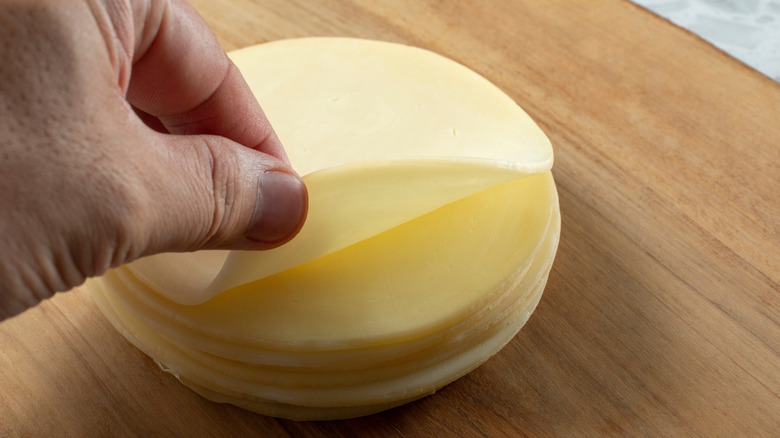 Hand picking up sliced provolone
